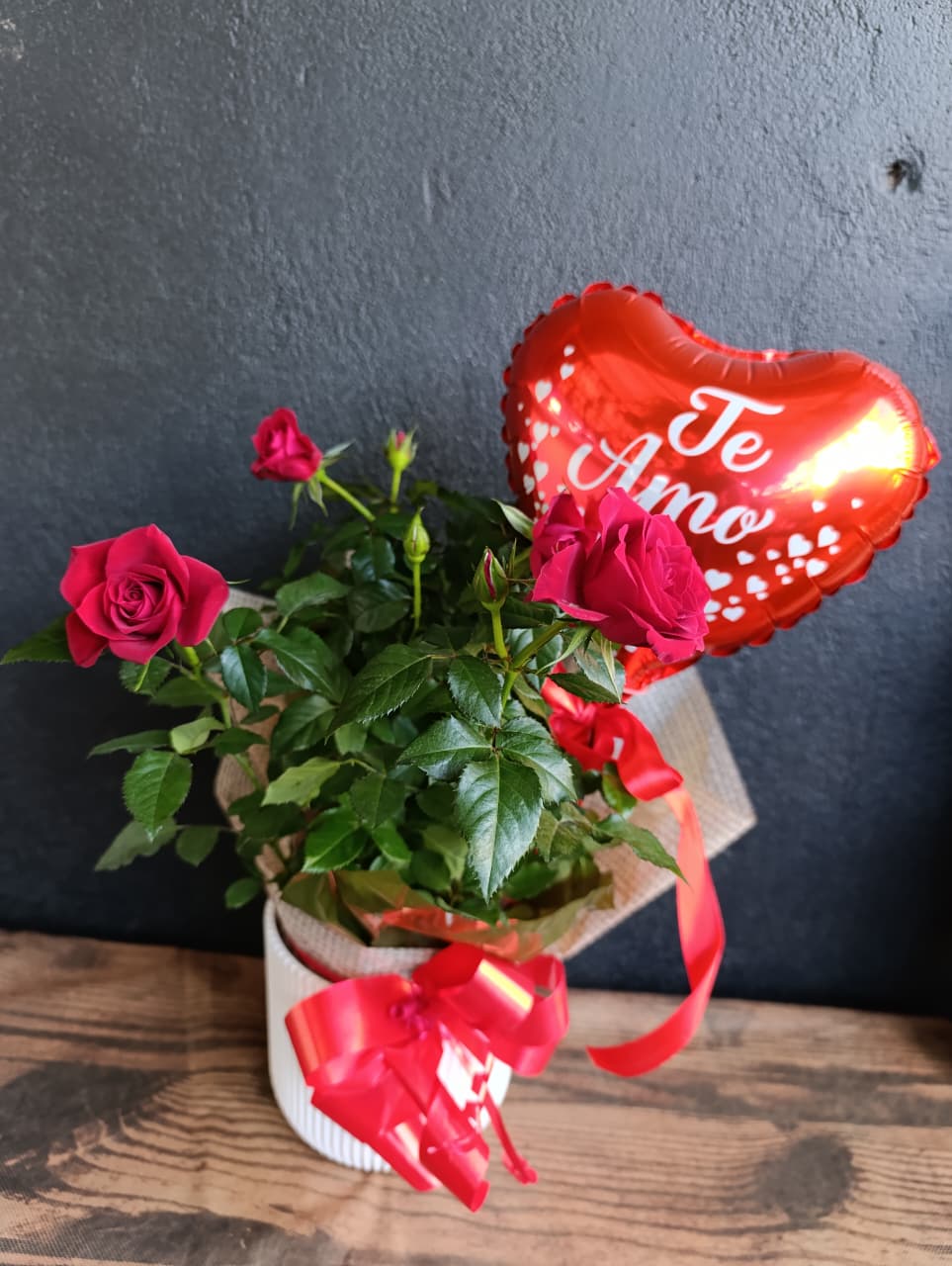 Rosa no cachepô decorativo com balão de coração